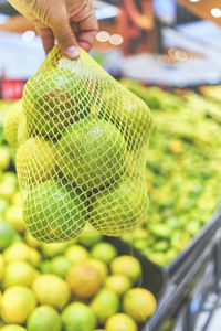 Close-up of hand holding fruits for sale at market stall