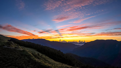 Scenic view of silhouette mountains against sky at sunset