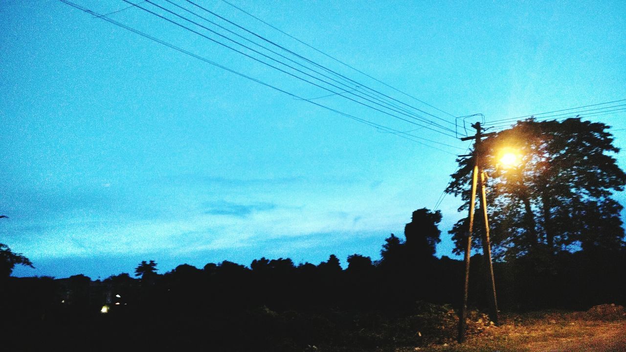 power line, electricity pylon, silhouette, electricity, low angle view, cable, power supply, sky, tree, street light, technology, blue, fuel and power generation, sun, lighting equipment, power cable, clear sky, connection, dusk, sunlight