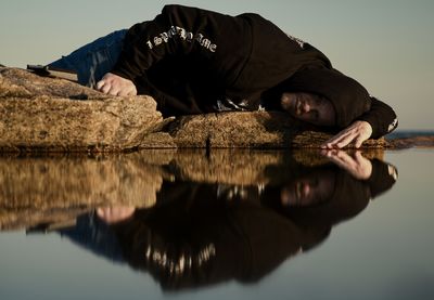 Portrait of young man standing by lake