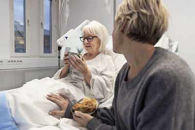 Adult daughter visiting mother in hospital