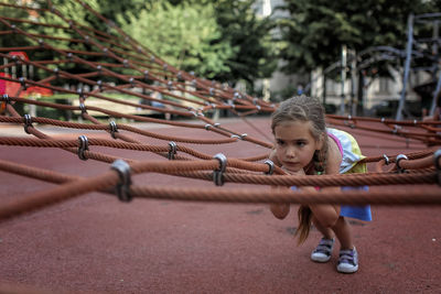 Girl lying on rope in public park