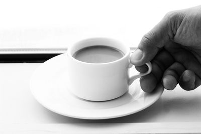 Close-up of hand holding coffee cup