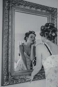 Portrait of young woman with reflection on mirror