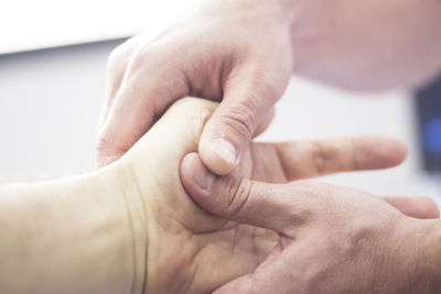 Close-up of doctor holding patient hand in hospital