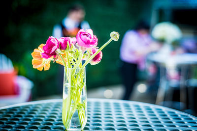 Close-up of flower vase on table at sidewalk cafe 