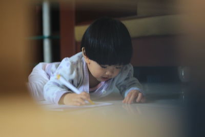 Portrait of boy looking at table at home