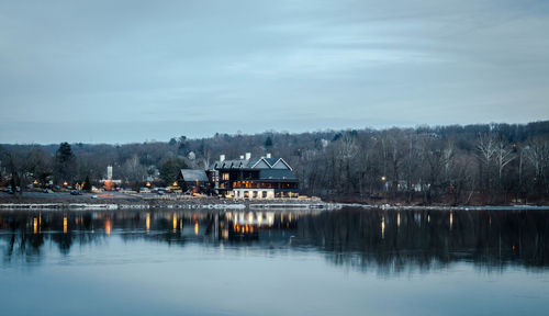 Scenic view of lake by buildings against sky