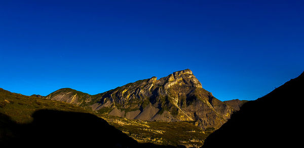 Scenic view of mountains against clear blue sky