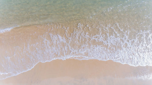 Waves flowing on seashore at beach