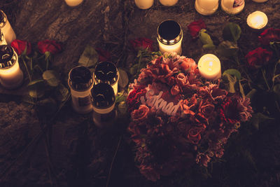 High angle view of lit tea light candles on table at night