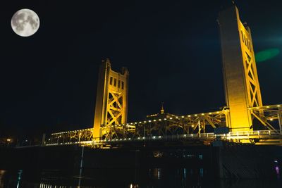 Low angle view of illuminated bridge against sky at night