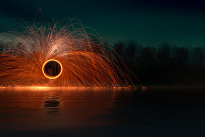 Light painting on lake against sky at night