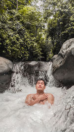 Portrait of shirtless man relaxing in water