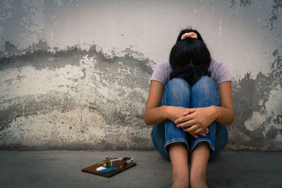 Side view of a teenage girl sitting outdoors