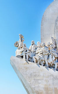 Low angle view of sculptures against clear sky on sunny day