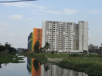 Reflection of building in lake against sky