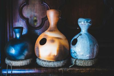 Close-up of pottery jugs on wooden shelf