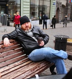 Man sitting on bench in city