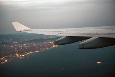 Aerial view of city by sea against sky