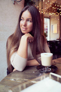 Portrait of woman with coffee cup on table