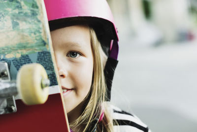 Portrait of smiling girl with skateboard at park