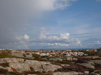 Aerial view of townscape by sea against sky