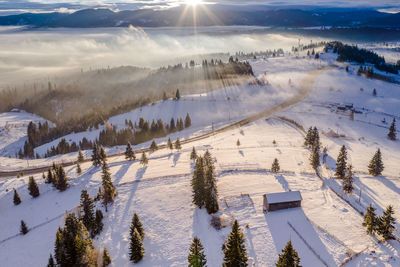 Scenic view of snow covered landscape against sky during sunset