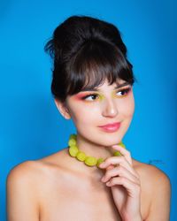 Portrait of woman against blue background