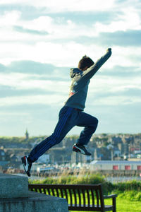 Full length of a man jumping against sky