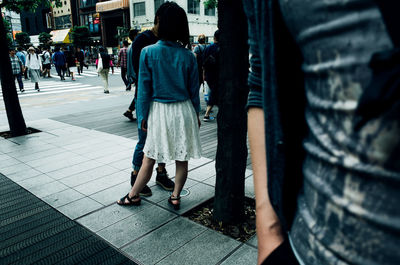 Rear view low section of woman walking on street