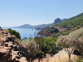 Scenic view of sea and mountains against clear sky