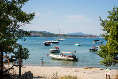 Boats moored in sea against sky