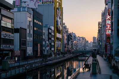 Street amidst buildings against sky at dusk