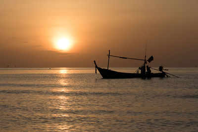 Silhouette boat in sea against sky during sunset