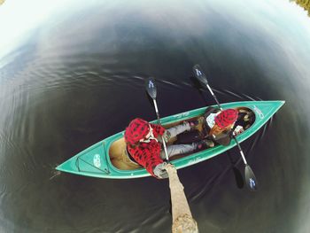 Overhead view of two people canoeing in water