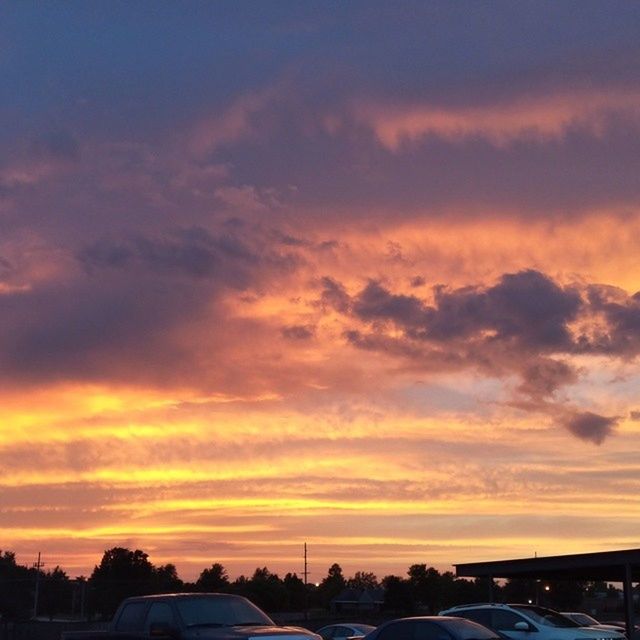 sunset, sky, orange color, cloud - sky, transportation, car, scenics, beauty in nature, building exterior, land vehicle, nature, road, dramatic sky, built structure, cloud, mode of transport, architecture, cloudy, silhouette, tranquil scene