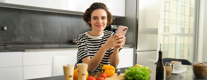 Portrait of young woman sitting in bathroom