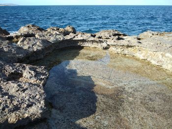 Scenic view of rocks on beach against sky