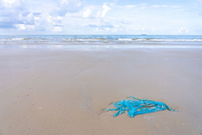 High angle view of blue plastic at beach against sky