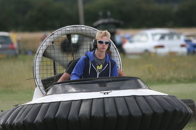 Teenager driving hovercraft on grass