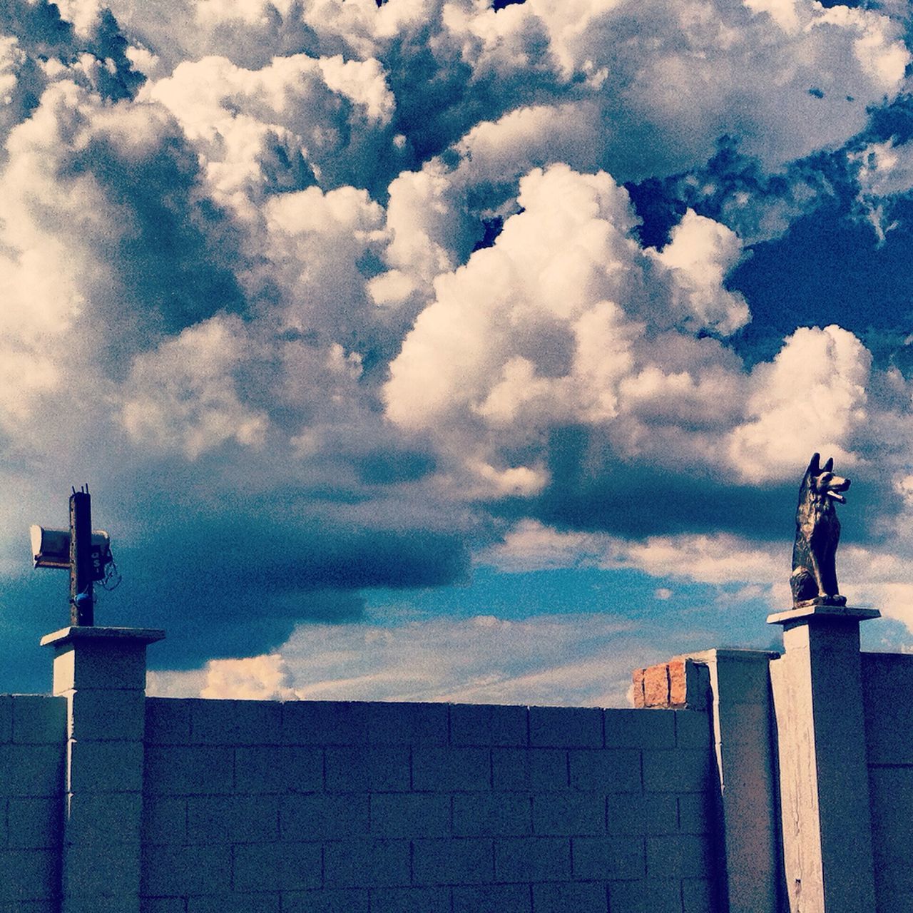 statue, sculpture, human representation, sky, low angle view, art and craft, art, built structure, cloud - sky, architecture, building exterior, creativity, animal representation, cloudy, cloud, outdoors, history, day