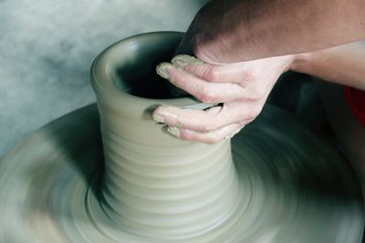 Cropped hand of craftsperson making pot