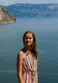 Portrait of smiling woman standing in sea