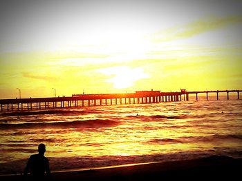 People on pier at sunset