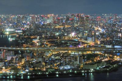 Illuminated cityscape against sky at night