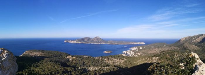 Panoramic view of sea and rocky mountains against sky