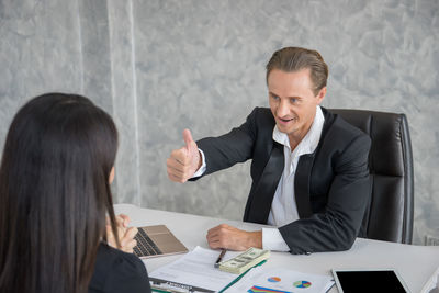 Business colleagues talking while working in office