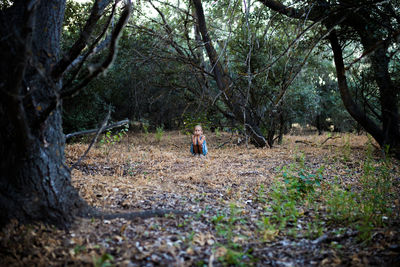 Girl crouching in forest