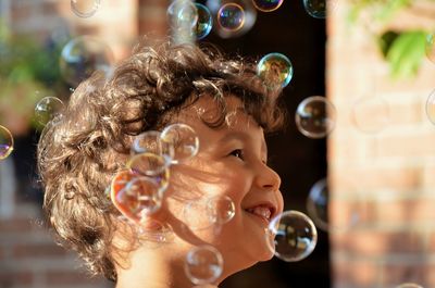 Cheerful of boy amidst bubbles